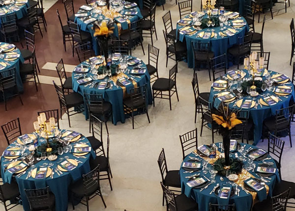 blue-tables-with-info Blue and gold decorations for several tables for an event.