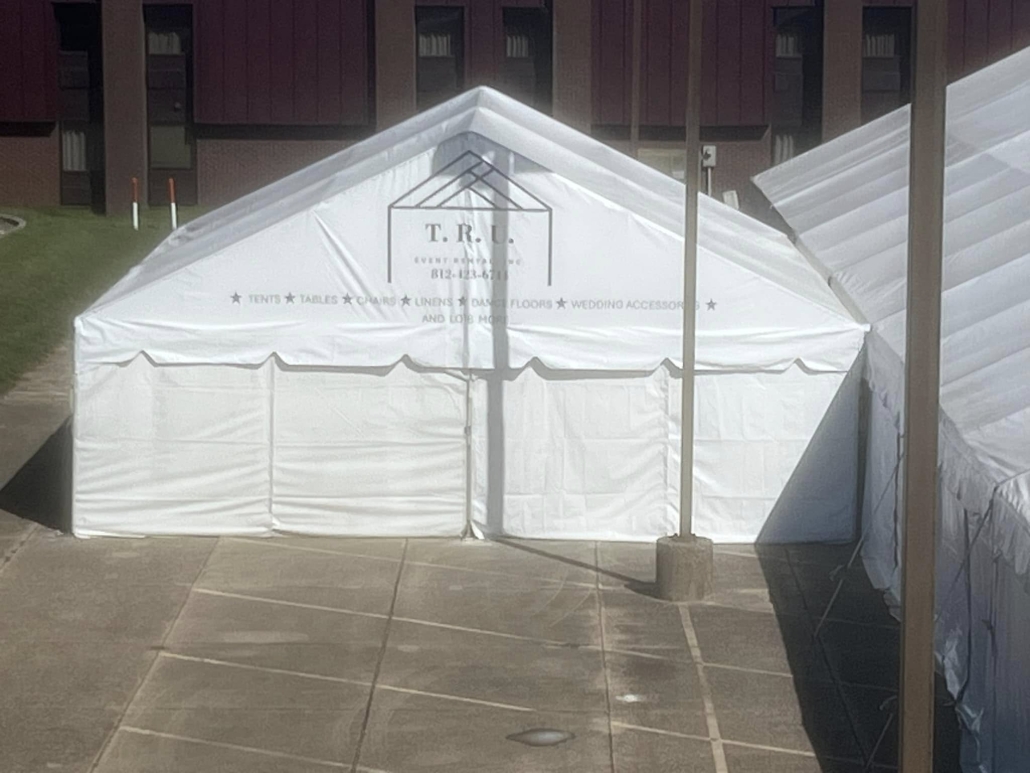 TRU event rentals logo on large tent in parking lot.